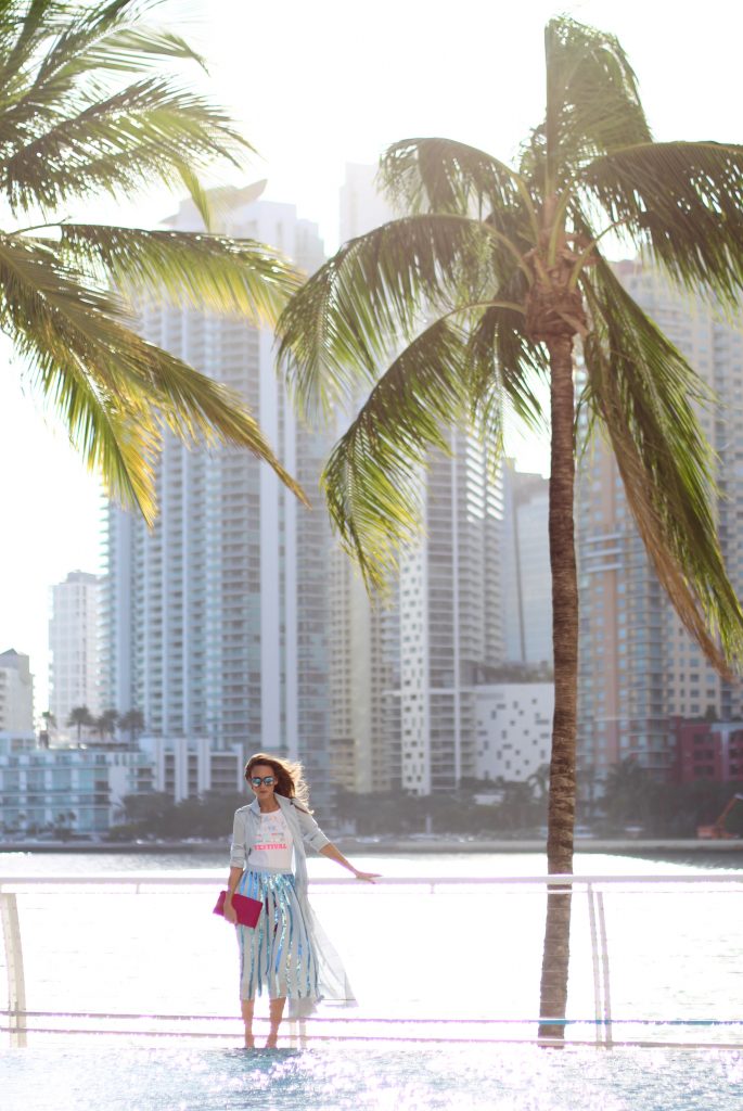 MANDARIN ORIENTAL; MIAMI; FLORIDA - JANUARY : German model and fashion blogger Alexandra Lapp (@alexandralapp_) wearing a light blue trenchcoat, a pleated skirt in metallic blue and a body from Patrizia Pepe, pink pumps and pink silk clutch by Prada and sunglasses from Le Specs on January, 2017 in Miami *** Local Caption *** Alexandra Lapp