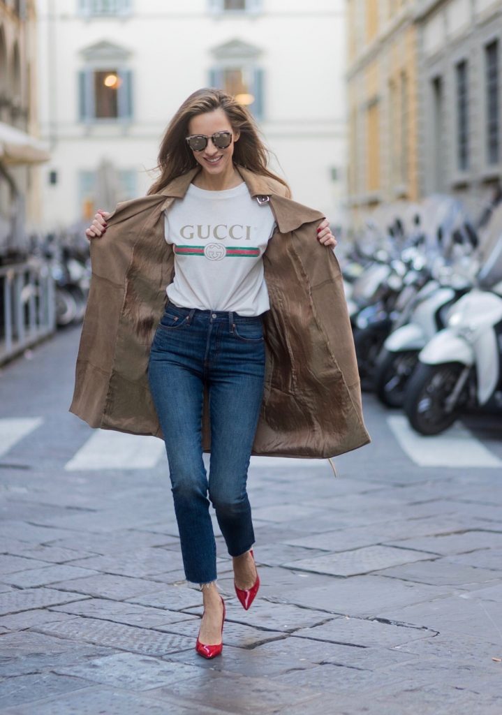 FLORENCE, ITALY - JANUARY 11: German fashion blogger and model Alexandra Lapp is wearing retro vibe Gucci printed cotton T-shirt, featuring a throwback Gucci logo, this piece features distressed detailing around the neckline, slim fit Wedgie Icon Fit Jeans from Levi’s, suede /buckskin leather trench coat from Oui, Dionysus GG Supreme Medium Gucci shoulder bag, Le Specs sunglasses, red pumps from Gianvito Rossi on January 11, 2017 in Florence, Italy. (Photo by Christian Vierig/Getty Images) *** Local Caption *** Alexandra Lapp