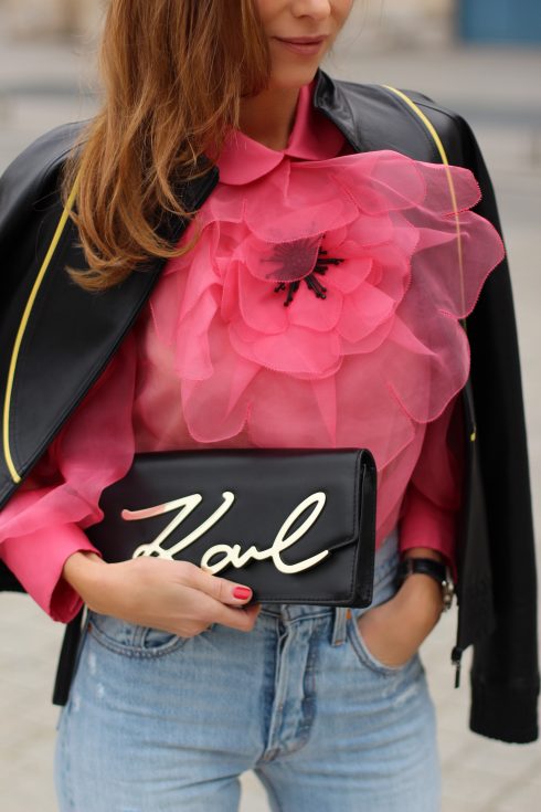 KARL IN PARIS, FRANCE - MARCH 04: Alexandra Lapp wearing a K Karl clutch bag with a gold application of Karl Lagerfeld's personal signature by Karl Lagerfeld, a pink Gucci blouse which is slightly transparent and decorated with a big blooming flower, a light blue Levi's 501 skinny jeans with button fly in the classic five-pocket design, a leather jacket with yellow details by Pearl & Rubies and pink pumps by Christian Louboutin on March 4, 2017 in Paris, France.