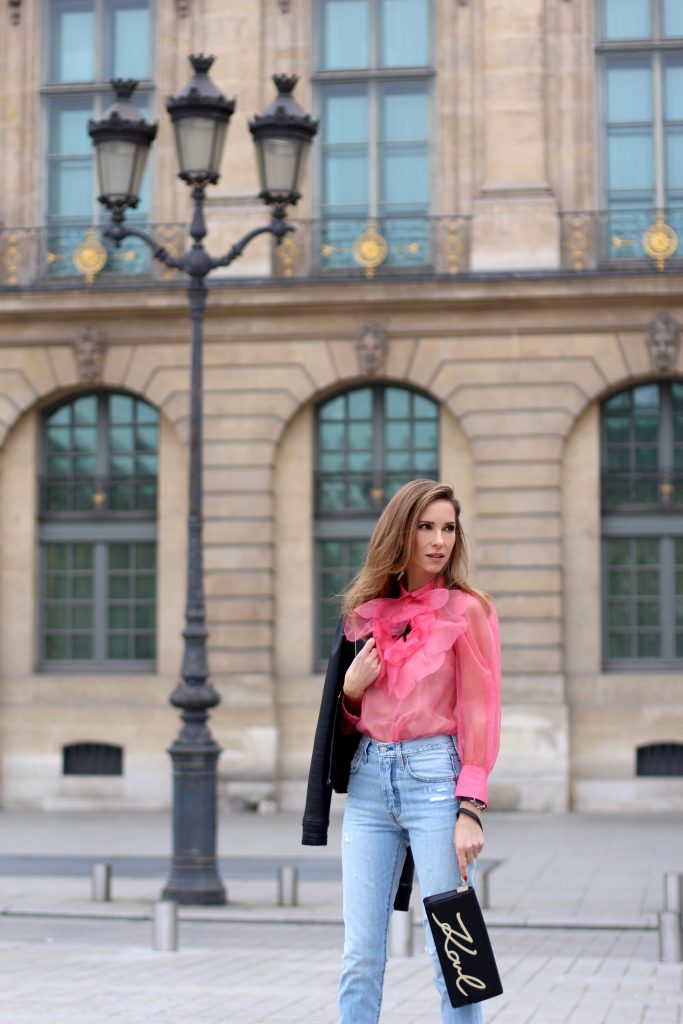 KARL IN PARIS, FRANCE - MARCH 04: Alexandra Lapp wearing a K Karl clutch bag with a gold application of Karl Lagerfeld's personal signature by Karl Lagerfeld, a pink Gucci blouse which is slightly transparent and decorated with a big blooming flower, a light blue Levi's 501 skinny jeans with button fly in the classic five-pocket design, a leather jacket with yellow details by Pearl & Rubies and pink pumps by Christian Louboutin on March 4, 2017 in Paris, France. 