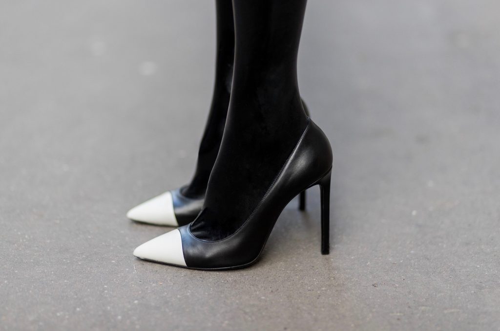 PARIS; FRANCE; RUE CAMBON; Model and Blogger Alexandra Lapp wearing black Couture Latex socks from Atsuko Kudo, coat from Steffen Schraut, Pumps by Saint Laurent, Cap from Chanel, Chanel Lego Brique (brick) bag in black and white, Sunglasses by Chromehearts on March 3, 2017 in Paris, France.