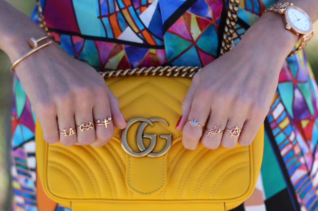Malibu, Los Angeles; Model and fashion blogger Alexandra Lapp wearing a colorful dress by La Martina, the Polo brand, sandals from Saint Laurent in black with golden rock studs, red lipstick from MAC, a yellow Gucci GG Marmont bag, IWC Da Vinci Automatic 36 watch in 18-carat red gold with diamonds and jewelry from AYS (Art Youth Society) in Malibu on April 17, 2017 in Los Angeles, California.