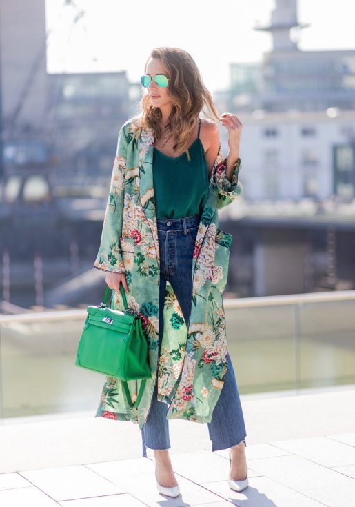 Model and fashion blogger Alexandra Lapp has a Kimono Love, wearing a green flower printed kimono from Zara, a green tank top in silk, blue jeans from Vetements in cooperation with LeviÂ´s with cut-out raw hems, white snake pumps from Christian Louboutin, Ray Ban Aviator sunglasses in green and a Hermes Kelly Ghillies 35 bag in green bamboo on March 30, 2017 in Duesseldorf, Germany.