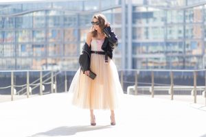 Model and fashion blogger Alexandra Lapp wearing a Carrie Bradshaw style, a multicolored sleeveless brocade tulle dress from Natasha Zinko, a black biker leather jacket with sewed on flowers with pearl applications from Natasha Zinko, black suede So Kate pums from Christian Louboutin, and black sunglasses from Celine on March 30, 2017 in Duesseldorf, Germany.