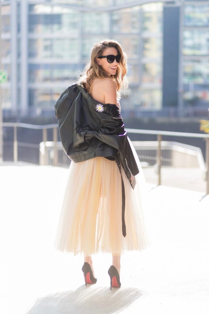 Model and fashion blogger Alexandra Lapp wearing a Carrie Bradshaw style, a multicolored sleeveless brocade tulle dress from Natasha Zinko, a black biker leather jacket with sewed on flowers with pearl applications from Natasha Zinko, black suede So Kate pums from Christian Louboutin, and black sunglasses from Celine on March 30, 2017 in Duesseldorf, Germany.