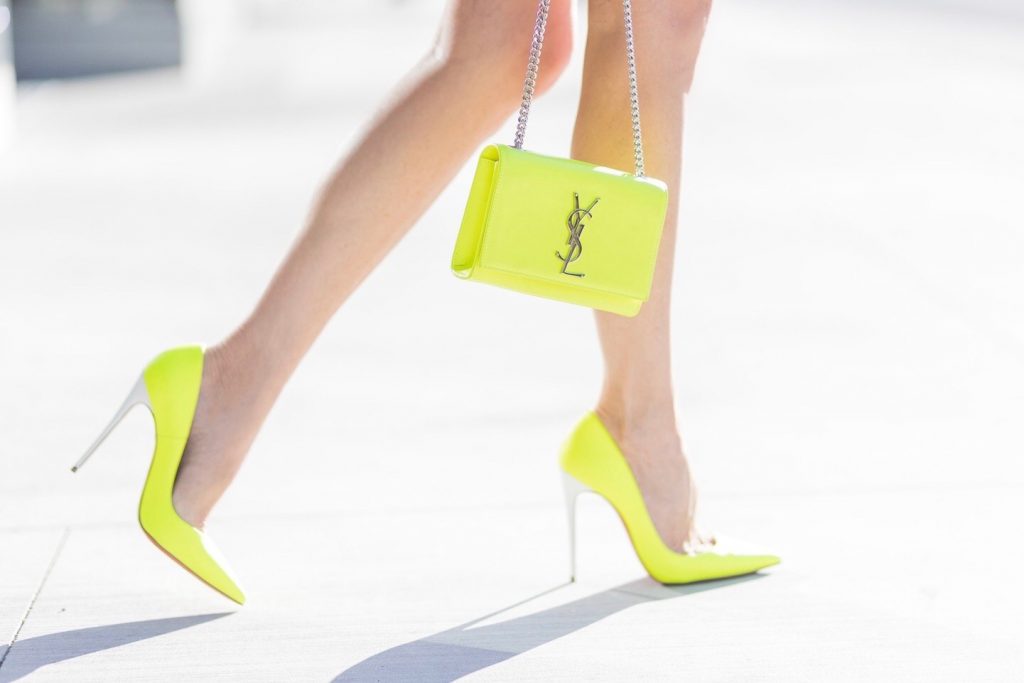 Model and fashion blogger Alexandra Lapp ' think pink ', wearing a multicolor mini leather skirt by Prabal Gurung, pink V neck cashmere pullover from Heartbreaker, neon yellow 'So Kate' pumps from Christian Louboutin, small sunset monogram Saint Laurent leather bag in neon yellow with YSL letters, Dior sunglasses so real in all black, IWC Da Vinci Automatic 36 watch in 18-carat red gold with diamonds and jewelry from AYS (Art Youth Society) on April 20, 2017 in Los Angeles, California.