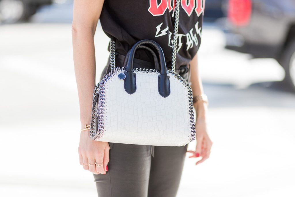 Model and fashion blogger Alexandra Lapp wearing V-Neck-Pumps, a LACE FRONT SKINNY LEATHER PANTS by Unravel, Dior High Voltage T-Shirt from Ecntrc, black and white vegan patent Stella McCartney check pointed toe V-neck-pumps with high-cut toe box, Falabella Box mini faux-leather cross-body bag in black and white, Chanel cap, Diormania sunglasses by Dior and Dior choker, IWC Da Vinci Automatic 36 watch in 18-carat red gold with diamonds and jewelry from AYS (Art Youth Society) on April 20, 2017 in Los Angeles, California.