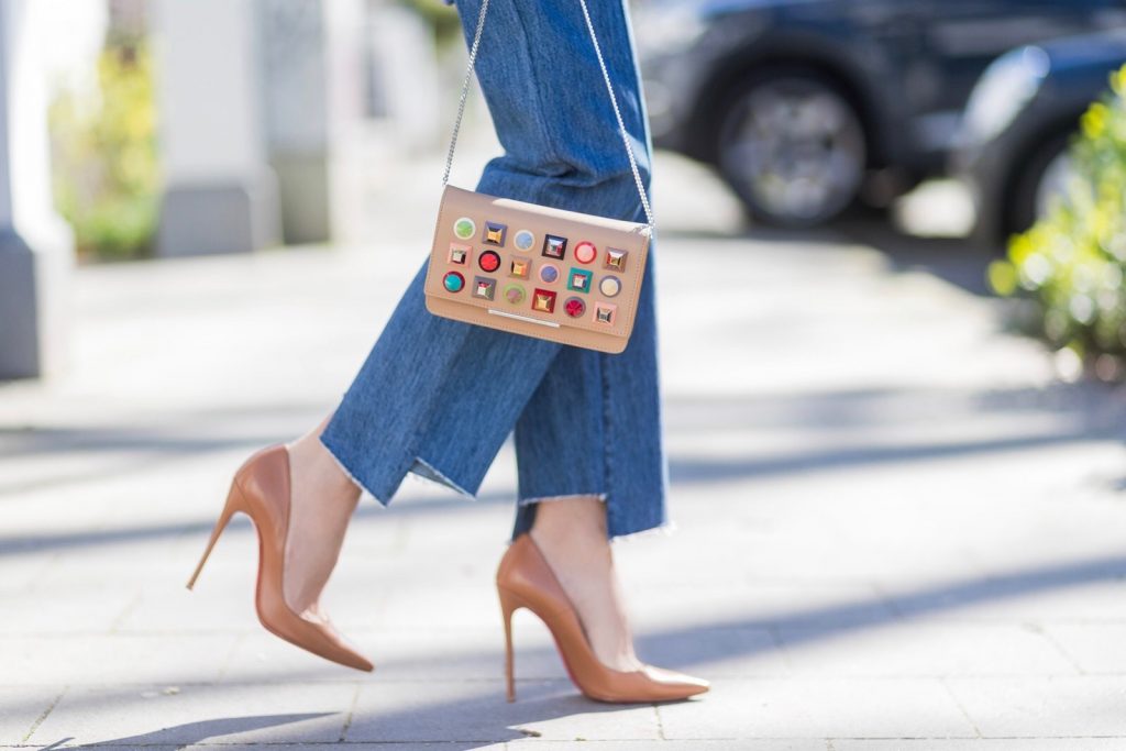 Vetements, Christian Louboutin, Fendi, Illevesta, AYS Model and fashion blogger Alexandra Lapp wearing an oversized navy and white striped cotton shirt, cut for an oversized fit with a point collar and dropped shoulders from Vetements, blue jeans from Vetements in cooperation with Levi`s with cut-out raw hems, blue aviator sunglasses from illevesta, Christian Louboutin pumps in cognac, filigree rose gold jewelry from Art Youth Society and a studded embellished crossbody bag from Fendi featuring a foldover top with magnetic closure, an interior zipped compartment, multiple interior card slots and a silver-tone chain shoulder strap on March 30, 2017 in Duesseldorf, Germany.