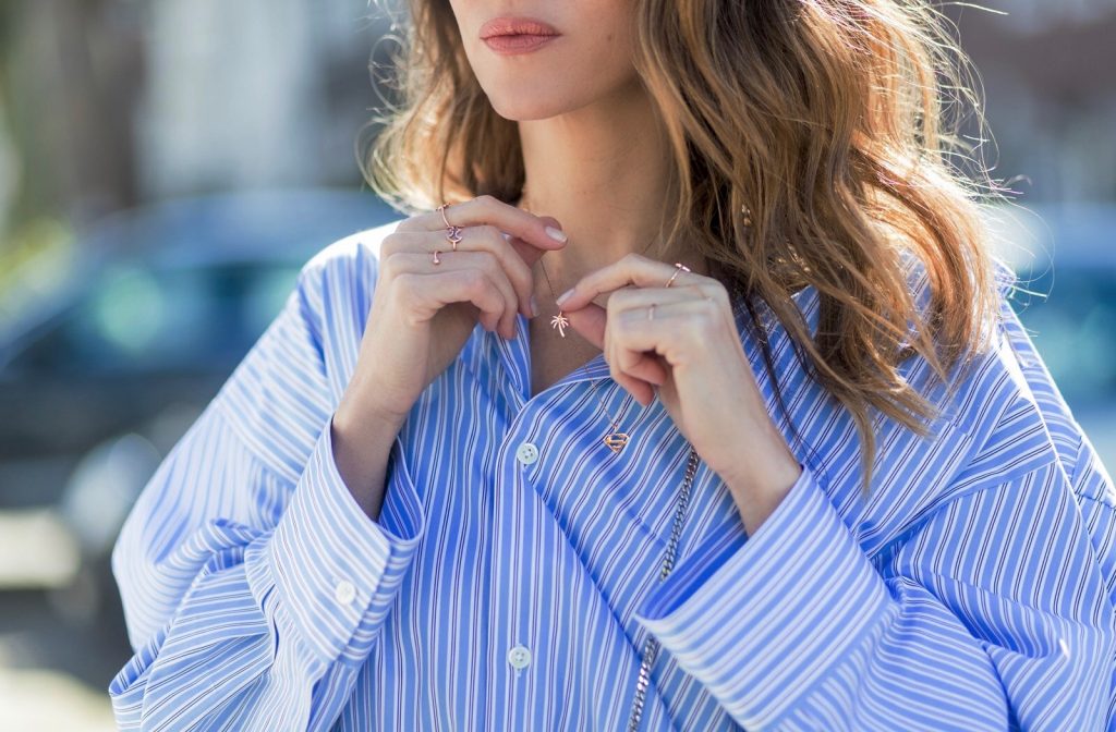 Vetements, Christian Louboutin, Fendi, Illevesta, AYS Model and fashion blogger Alexandra Lapp wearing an oversized navy and white striped cotton shirt, cut for an oversized fit with a point collar and dropped shoulders from Vetements, blue jeans from Vetements in cooperation with Levi`s with cut-out raw hems, blue aviator sunglasses from illevesta, Christian Louboutin pumps in cognac, filigree rose gold jewelry from Art Youth Society and a studded embellished crossbody bag from Fendi featuring a foldover top with magnetic closure, an interior zipped compartment, multiple interior card slots and a silver-tone chain shoulder strap on March 30, 2017 in Duesseldorf, Germany.