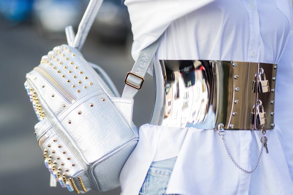 Model and fashion blogger Alexandra Lapp wearing a heavy metal belt in form from a lace up metal corset with locks and keys by Dolce & Gabbana, white shirt from Steffen Schraut, Levi's 501 skinny jeans, brown mules with a shiny buckle from Roger Vivier Paris, mirrored sunglasses from Les Specs, stark pearl studs backpack in silver from MCM, filigree jewelry in rose gold from Art Youth Society on March 30, 2017 in Duesseldorf, Germany.