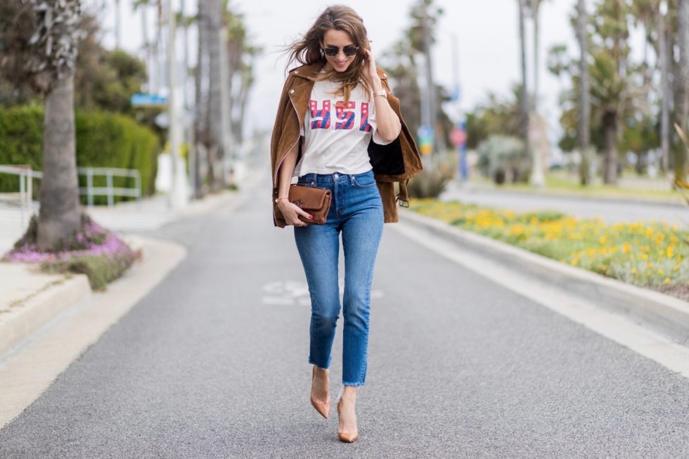 Model and fashion blogger Alexandra Lapp wearing a suede biker Jacket from Tigha, Wedgie Icon Fit jeans, slim fit in dark blue by Levi's, washed rose cotton YSL USA cropped T-shirt from Saint Laurent featuring a ribbed round neck, dropped shoulders, short sleeves, a print to the front, a straight hem and a loose fit, Christian Louboutin pumps 'So Kate' in brown cognac, Chanel bag 2.55 with a big Coco Chanel Logo, Ray Ban Clubmaster sunglasses, IWC Da Vinci Automatic 36 watch in 18-carat red gold with diamonds and jewelry from AYS (Art Youth Society) on April 19, 2017 in Los Angeles, California.
