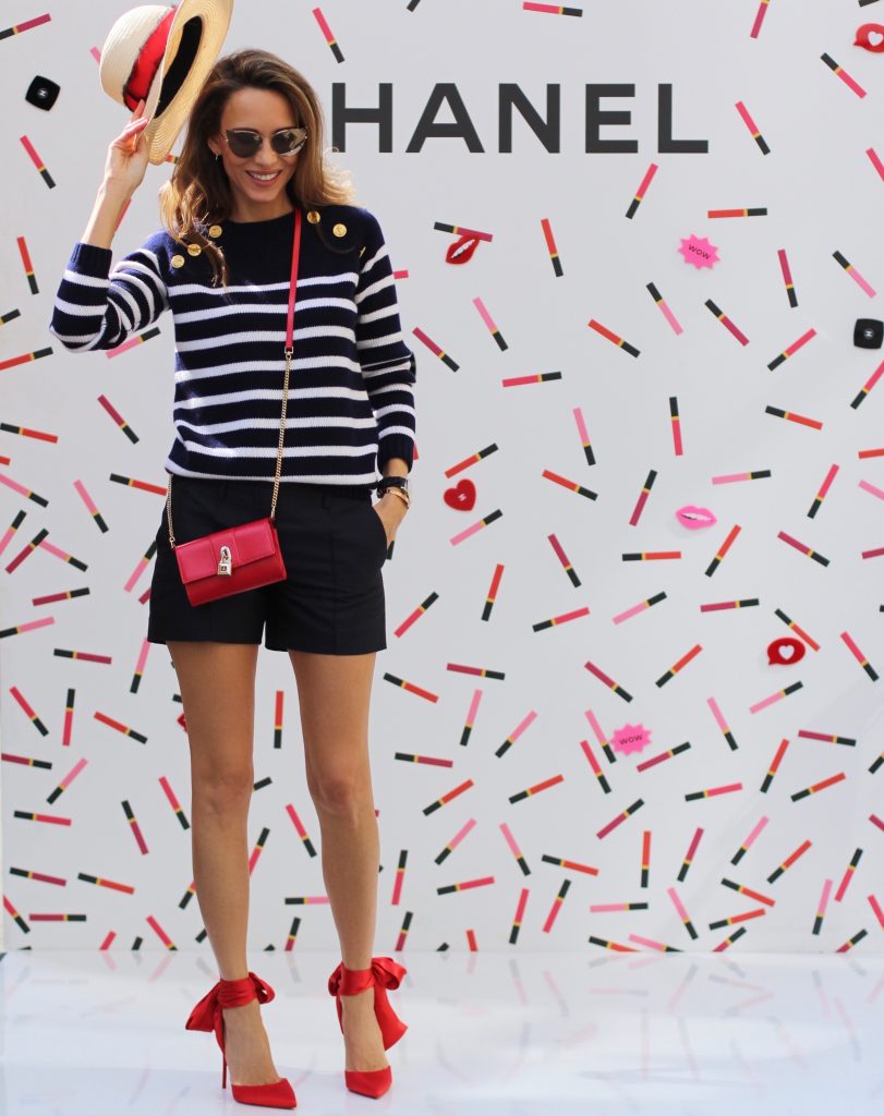Model and Blogger Alexandra Lapp sitting at Coco Café #cococafe in Duesseldorf, wearing a blue white striped cashmere pullover with gold buttons from Heartbreaker, a dark blue silk shorts by Prada, satin Douce du desert pumps in red with a big silk bow from Christian Louboutin, red crossover purse-bag from Patrizia Pepe and gold cat-eye sunglasses from KARL by Karl Lagerfeld, in Duesseldorf on June, 14th 2017. 
