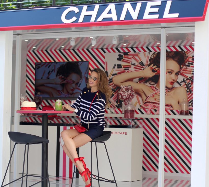 Model and Blogger Alexandra Lapp sitting at Coco Café #cococafe in Duesseldorf, wearing a blue white striped cashmere pullover with gold buttons from Heartbreaker, a dark blue silk shorts by Prada, satin Douce du desert pumps in red with a big silk bow from Christian Louboutin, red crossover purse-bag from Patrizia Pepe and gold cat-eye sunglasses from KARL by Karl Lagerfeld, in Duesseldorf on June, 14th 2017.