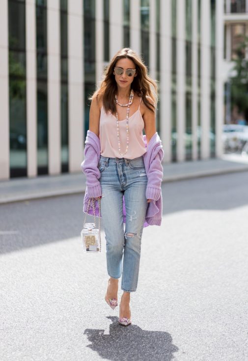 Alexandra Lapp wearing a pastel purple look, a purple cashmere cardigan by Heartbreaker, a rose tank top in silk from Jadicted, a high waist, non-strech denim, five-pocket 501 skinny jeans from Levis, a candy necklace from Chanel supermarket collection in pastel tones, a Chanel perfume bottle bag in plexiglass and a golden chain with white leather, Christian Louboutin pumps Feerica with nude mesh upper embedded with a Swarovski crystal degrade and Karl Lagerfeld cat-eye sunglasses in the shape of cat ears during the Mercedes-Benz Fashion Week Berlin Spring/Summer 2018 on July 7, 2017 in Berlin, Germany.