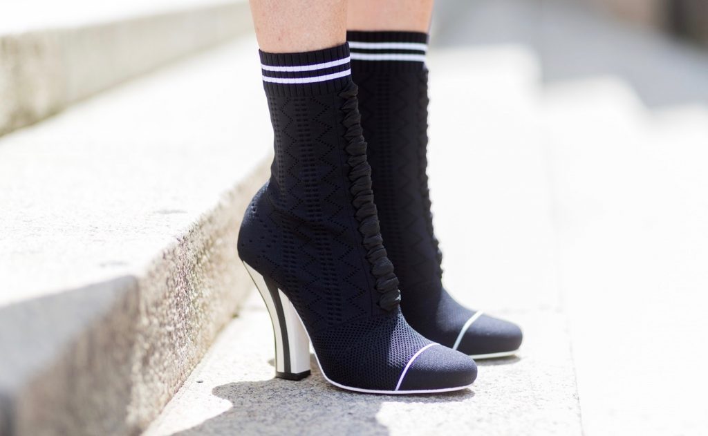 Sock Boots, Fendi, Valentino R.E.D., MCM, Ray Ban, Berlin, MBFWB, MBFW Alexandra Lapp (model, blogger) wearing Fendis SS 17 collection sock boots with a grey knit upper, with a high sculptural heel, a black silk chiffon mini dress with gilded stars from RED Valentino with a tie at the neck and a ruffle through the hem, a MCM Patricia Shoulder Bag crafted in in Visetos-print coated canvas and topped with crystalized appliqués, including the Punk Rabbit, accented with mink fur, studwork and edge painting and a laurel-engraved case latch closure and Ray Ban aviator sunglasses in gold during the Mercedes-Benz Fashion Week Berlin Spring/Summer 2018 on July 6, 2017 in Berlin, Germany.