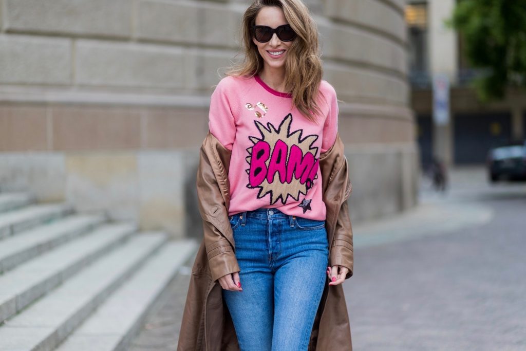Alexandra Lapp wearing a leather coat in cognac by Riani, a round neck pullover, printed with BAM in comic style and pailettes, Levis Wedgie Icon Fit jeans in slim fit and dark blue, a Boy bag in metallic pink patent leather, Gucci sunglasses and cognac So Kate high heels from Christian Louboutin during the Mercedes-Benz Fashion Week Berlin Spring/Summer 2018 on July 7, 2017 in Berlin, Germany.