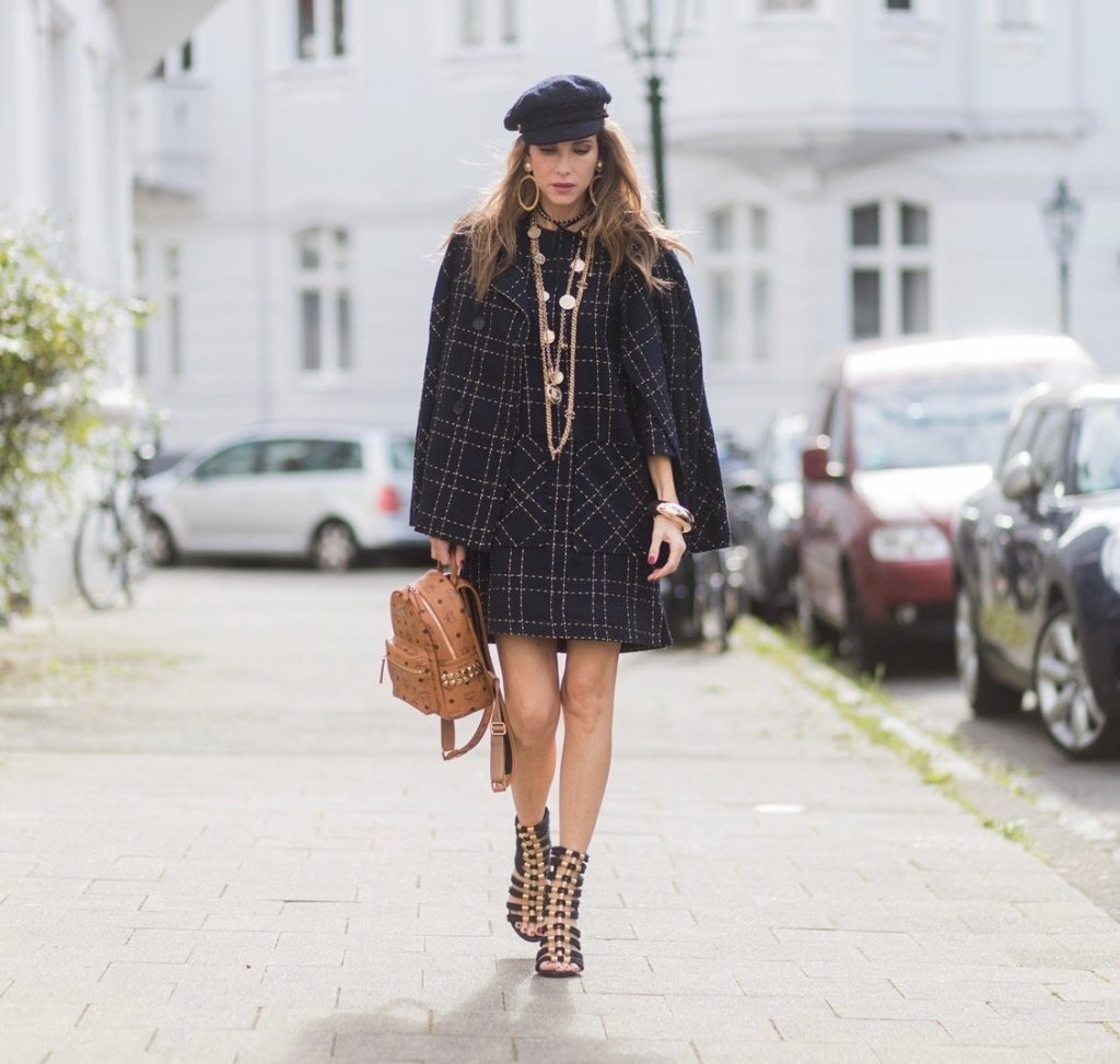 Model and fashion blogger Alexandra Lapp wearing a look inspired by Chanel, a tweed dress and coat from Steffen Schraut, Balmain x HM sandals, Strak backpack by MCM, Chanel tweed cap, golden Chanel chains in form from Chanel coins, Chanel chocker and golden bracelet from Schubart Goldschmiede and golden vintage earrings with a peals by Chanel on August 5, 2017 in Duesseldorf, Germany.