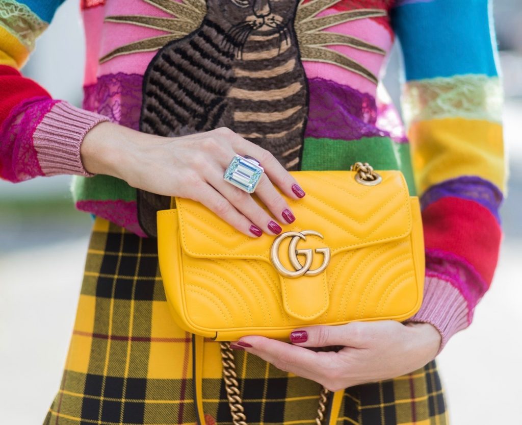Gucci, Celine, Schubart, Christian Louboutin, Model and Blogger Alexandra Lapp wearing a Gucci total look, yellow and red pleated tartan skirt embroidered with a spaniel dog and belt buckle closure, colorful striped sweater with lace and merino with embroidered cat applique all Gucci, black Christian Louboutin So Kate pumps, GG Marmont Gucci bag in yellow, Audrey sunglasses from Celine on August 4, 2017 in Duesseldorf, Germany.