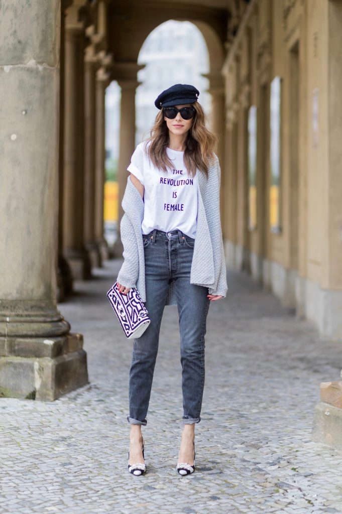 Alexandra Lapp wearing a T-Shirt from H&M, printed with The Revolution Is Female, a high waist, non-strech denim, five-pocket 501 skinny jeans from Levis in grey, Cashmere cardigan in grey, Roger Vivier pumps in a sharp cut and sheeny satin fabric in black and white stripes with crystal flower-embellished buckle at the front and sling-back shape and the 2.55 classic Chanel bag in white leather with black pearls during the Mercedes-Benz Fashion Week Berlin Spring/Summer 2018 on July 7, 2017 in Berlin, Germany.