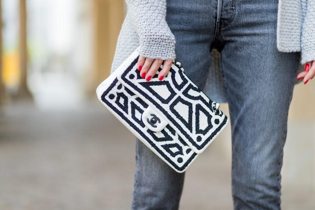 Alexandra Lapp wearing a T-Shirt from H&M, printed with The Revolution Is Female, a high waist, non-strech denim, five-pocket 501 skinny jeans from Levis in grey, Cashmere cardigan in grey, Roger Vivier pumps in a sharp cut and sheeny satin fabric in black and white stripes with crystal flower-embellished buckle at the front and sling-back shape and the 2.55 classic Chanel bag in white leather with black pearls during the Mercedes-Benz Fashion Week Berlin Spring/Summer 2018 on July 7, 2017 in Berlin, Germany.