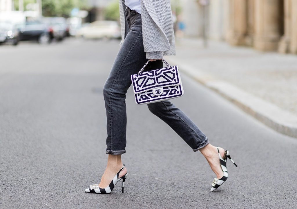 Alexandra Lapp wearing a T-Shirt from H&M, printed with The Revolution Is Female, a high waist, non-strech denim, five-pocket 501 skinny jeans from Levis in grey, Cashmere cardigan in grey, Roger Vivier pumps in a sharp cut and sheeny satin fabric in black and white stripes with crystal flower-embellished buckle at the front and sling-back shape and the 2.55 classic Chanel bag in white leather with black pearls during the Mercedes-Benz Fashion Week Berlin Spring/Summer 2018 on July 7, 2017 in Berlin, Germany.