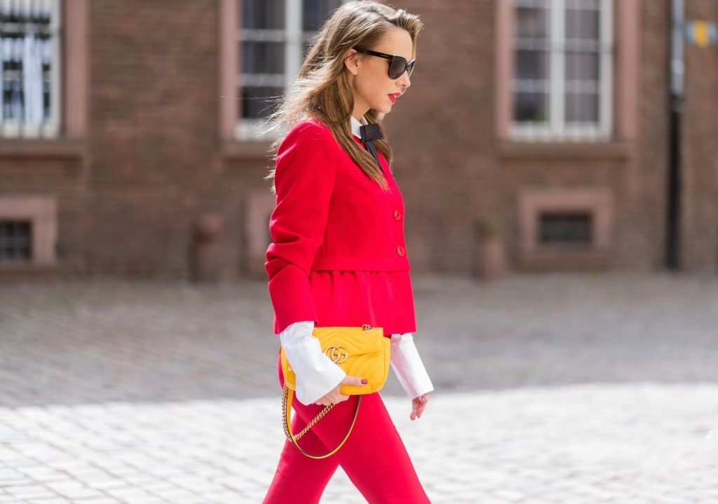 Model and fashion blogger Alexandra Lapp wearing a slim fit, red suit from Steffen Schraut, blazer with peplum and red pants, white blouse with a black ribbon bow from Steffen Schraut, white pumps with black toecap from Saint Laurent, Chanel sunglasses with pearls and yellow GG Marmont bag from Gucci on August 5, 2017 in Duesseldorf, Germany.