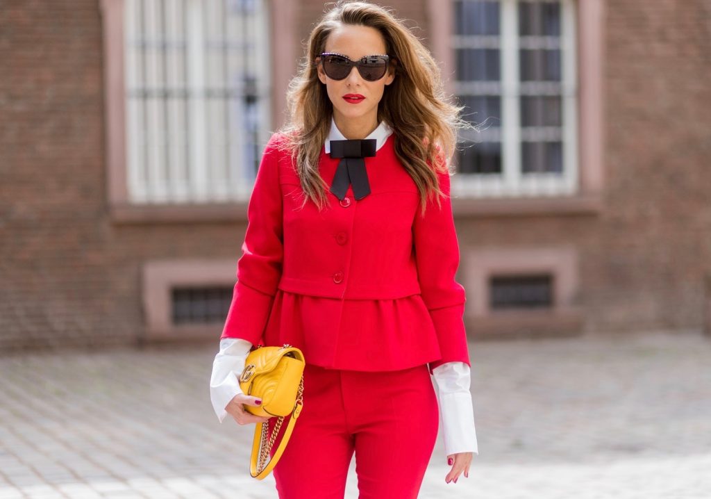 Model and fashion blogger Alexandra Lapp wearing a slim fit, red suit from Steffen Schraut, blazer with peplum and red pants, white blouse with a black ribbon bow from Steffen Schraut, white pumps with black toecap from Saint Laurent, Chanel sunglasses with pearls and yellow GG Marmont bag from Gucci on August 5, 2017 in Duesseldorf, Germany.