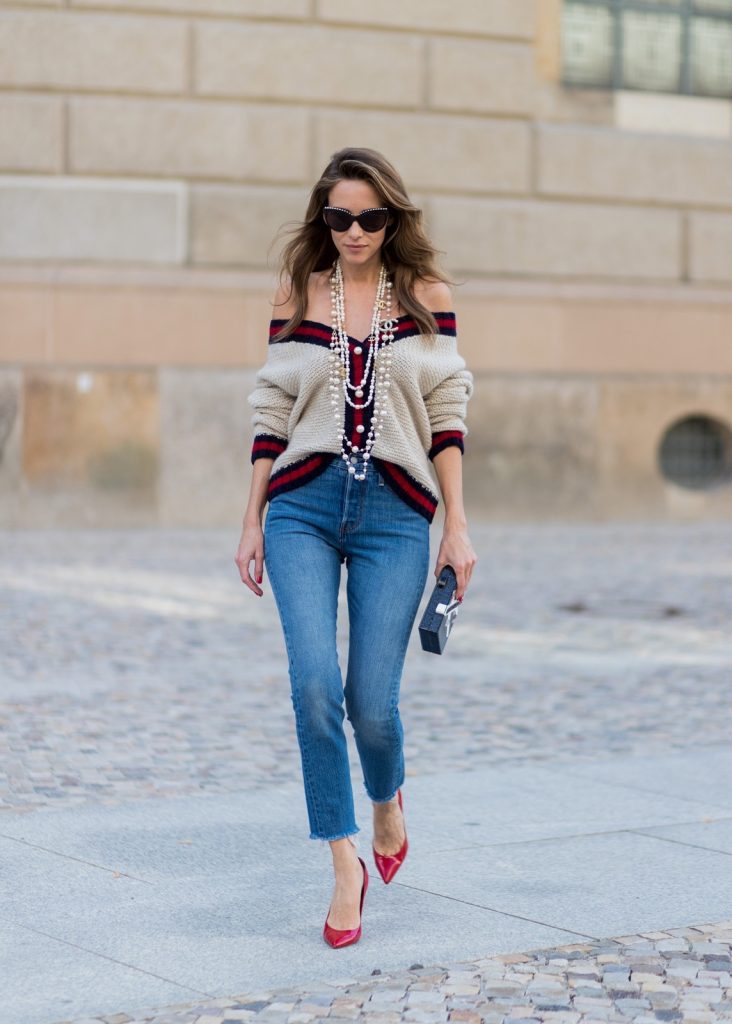 Alexandra Lapp wearing a cashmere cardigan with pearls in beige with a collar in blue and red Levis Wedgie Icon Fit jeans in slim fit and dark blue, a long, pearl necklace from Chanel with the Chanel Logo, brown sunglasses with pearls from Chanel, Fly with Karl clutch from Karl Lagerfeld and cognac So Kate high heels from Christian Louboutin during the Mercedes-Benz Fashion Week Berlin Spring/Summer 2018 on July 7, 2017 in Berlin, Germany.