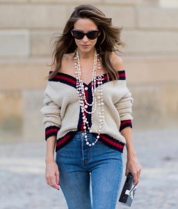 Alexandra Lapp wearing a cashmere cardigan with pearls in beige with a collar in blue and red Levis Wedgie Icon Fit jeans in slim fit and dark blue, a long, pearl necklace from Chanel with the Chanel Logo, brown sunglasses with pearls from Chanel, Fly with Karl clutch from Karl Lagerfeld and cognac So Kate high heels from Christian Louboutin during the Mercedes-Benz Fashion Week Berlin Spring/Summer 2018 on July 7, 2017 in Berlin, Germany.