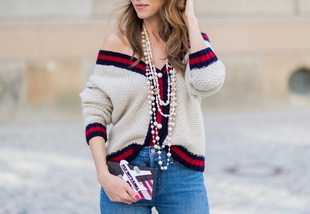 Alexandra Lapp wearing a cashmere cardigan with pearls in beige with a collar in blue and red Levis Wedgie Icon Fit jeans in slim fit and dark blue, a long, pearl necklace from Chanel with the Chanel Logo, brown sunglasses with pearls from Chanel, Fly with Karl clutch from Karl Lagerfeld and cognac So Kate high heels from Christian Louboutin during the Mercedes-Benz Fashion Week Berlin Spring/Summer 2018 on July 7, 2017 in Berlin, Germany.