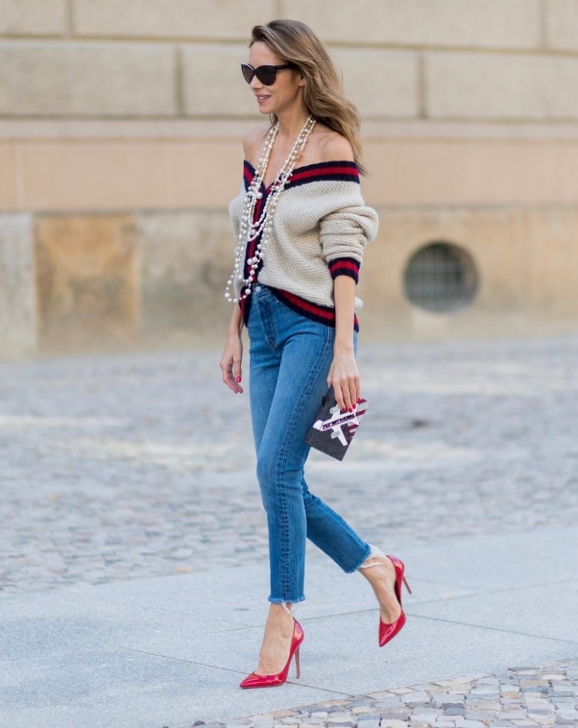 Alexandra Lapp wearing a cashmere cardigan with pearls in beige with a collar in blue and red Levis Wedgie Icon Fit jeans in slim fit and dark blue, a long, pearl necklace from Chanel with the Chanel Logo, brown sunglasses with pearls from Chanel, Fly with Karl clutch from Karl Lagerfeld and cognac So Kate high heels from Christian Louboutin during the Mercedes-Benz Fashion Week Berlin Spring/Summer 2018 on July 7, 2017 in Berlin, Germany.