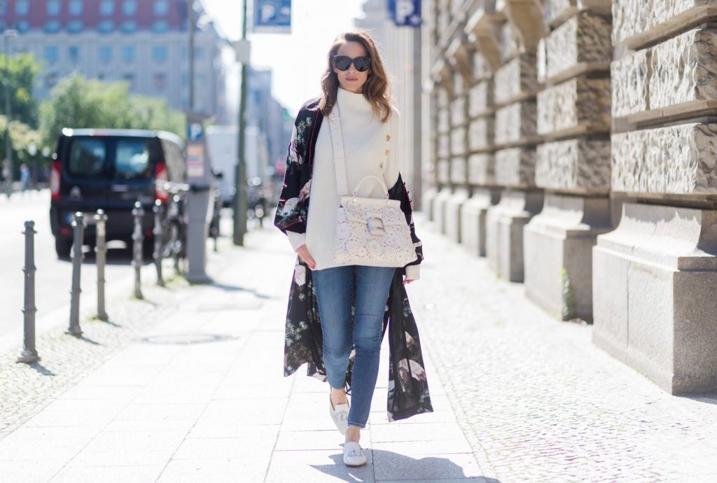 Model and fashion blogger Alexandra Lapp wearing white leather tassel mules from Santoni. a off white cashmere pullover by Heartbreaker, Kimono with velvet collar from Zara, Adriano Goldschmied AG jeans, Roger Viv bag in suede with waterjet cut Guipure detailing, metal buckle and details, removable strap in trapezium shape, silver mirrored sunglasses from Le Spec during the Mercedes-Benz Fashion Week Berlin Spring/Summer 2018 on July 8, 2017 in Berlin, Germany.