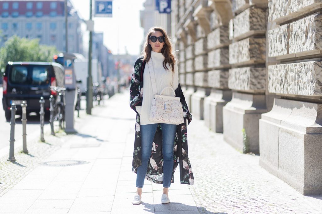 Model and fashion blogger Alexandra Lapp wearing white leather tassel mules from Santoni. a off white cashmere pullover by Heartbreaker, Kimono with velvet collar from Zara, Adriano Goldschmied AG jeans, Roger Viv bag in suede with waterjet cut Guipure detailing, metal buckle and details, removable strap in trapezium shape, silver mirrored sunglasses from Le Spec during the Mercedes-Benz Fashion Week Berlin Spring/Summer 2018 on July 8, 2017 in Berlin, Germany.