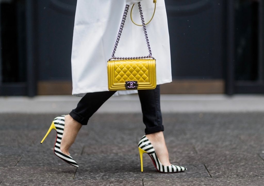 Couple look a like holding arms in front of a DHL van - Model and Blogger Alexandra Lapp wearing oversized Vetements raincoat with a hood in white, Vetements hoodie in white, destroyed Adriano Goldschmied high waist denim in black, black and white So Kate pumps with a yellow heel, yellow golden lacquer Boy bag from Chanel and a big golden ring with baguette diamonds from Schubart Goldschmiede and Model and Blogger Thomas Stuch wearing black oversized raincoat with a hood in black from Vetements, Stella McCartney hoodie in black, Dsquared slim fit denim, Ghost cowboy boots on August 4, 2017 in Duesseldorf, Germany.