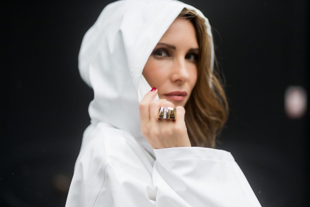 Couple look a like holding arms in front of a DHL van - Model and Blogger Alexandra Lapp wearing oversized Vetements raincoat with a hood in white, Vetements hoodie in white, destroyed Adriano Goldschmied high waist denim in black, black and white So Kate pumps with a yellow heel, yellow golden lacquer Boy bag from Chanel and a big golden ring with baguette diamonds from Schubart Goldschmiede and Model and Blogger Thomas Stuch wearing black oversized raincoat with a hood in black from Vetements, Stella McCartney hoodie in black, Dsquared slim fit denim, Ghost cowboy boots on August 4, 2017 in Duesseldorf, Germany.