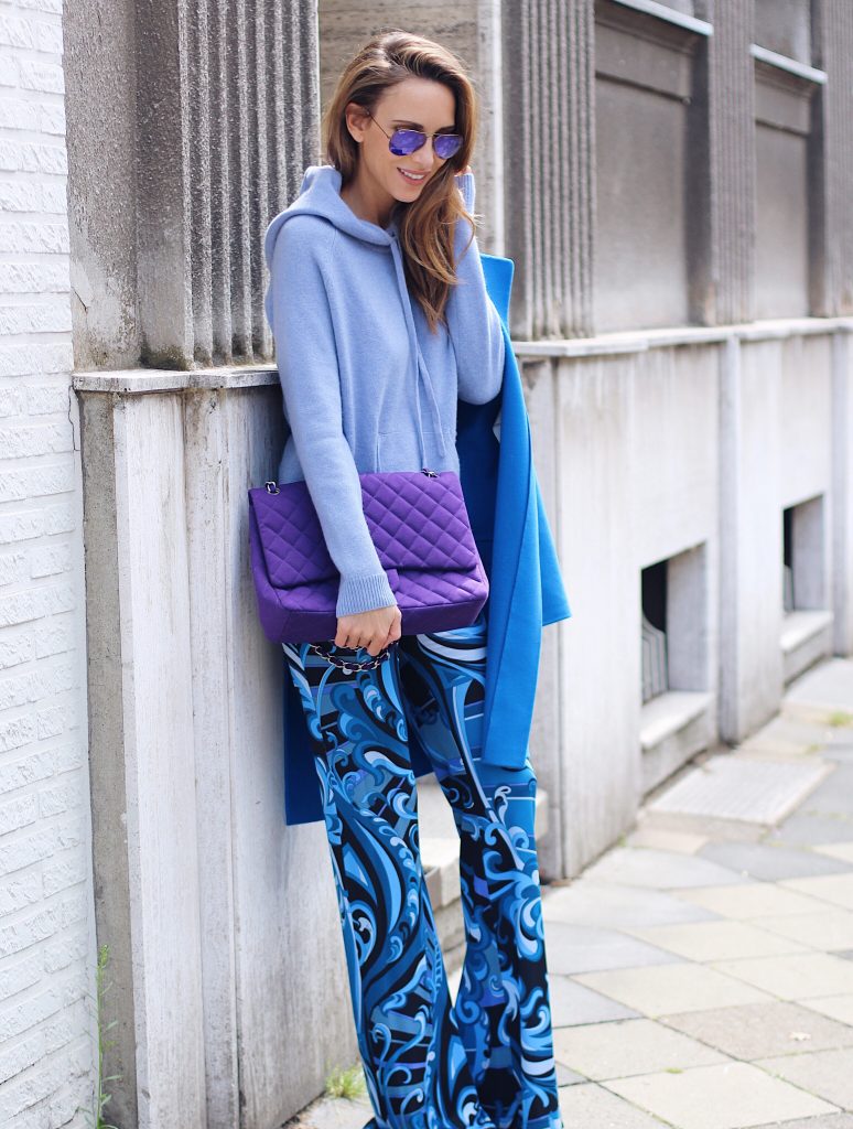  Alexandra Lapp wearing a light blue cashmere hoodie by Heartbreaker, colorful pants in all tones of blue from Emilio Pucci, a blue cashmere coat by Jil Sander, an oversized purple 2.55 tweed bag from Chanel, purple aviator sunglasses from Ray Ban, Gianvito Rossi heels.