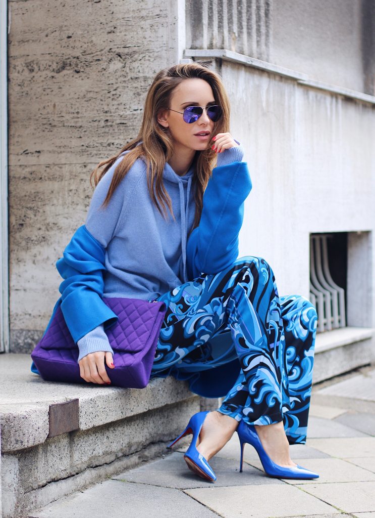  Alexandra Lapp wearing a light blue cashmere hoodie by Heartbreaker, colorful pants in all tones of blue from Emilio Pucci, a blue cashmere coat by Jil Sander, an oversized purple 2.55 tweed bag from Chanel, purple aviator sunglasses from Ray Ban, Gianvito Rossi heels.