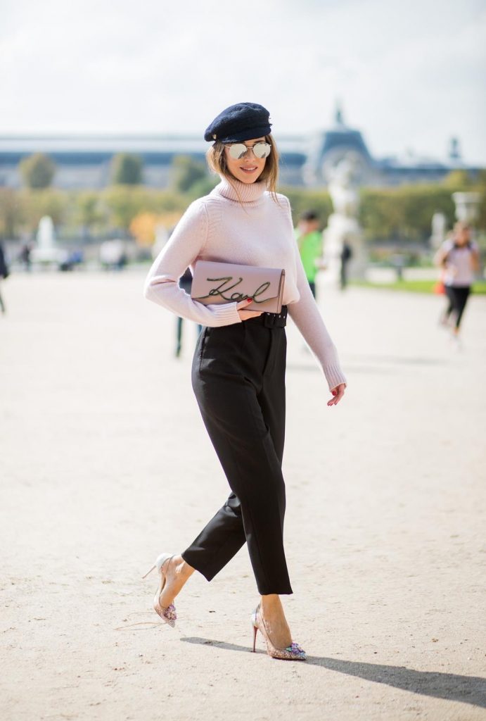 Alexandra Lapp wearing high waist pants in black from Zara, cashmere turtleneck in light pink from Jil Sander, light pink calf leather logo plaque shoulder bag from Karl Lagerfeld, Karl Lagerfeld bag, mirrored sunglasses by Le Specs, hat by Chanel, IWC Portugieser watch and Christian Louboutin Feerica heels with crystal embellished flower and glitter is seen during Paris Fashion Week Spring/Summer 2018 on September 29, 2017 in Paris, France.