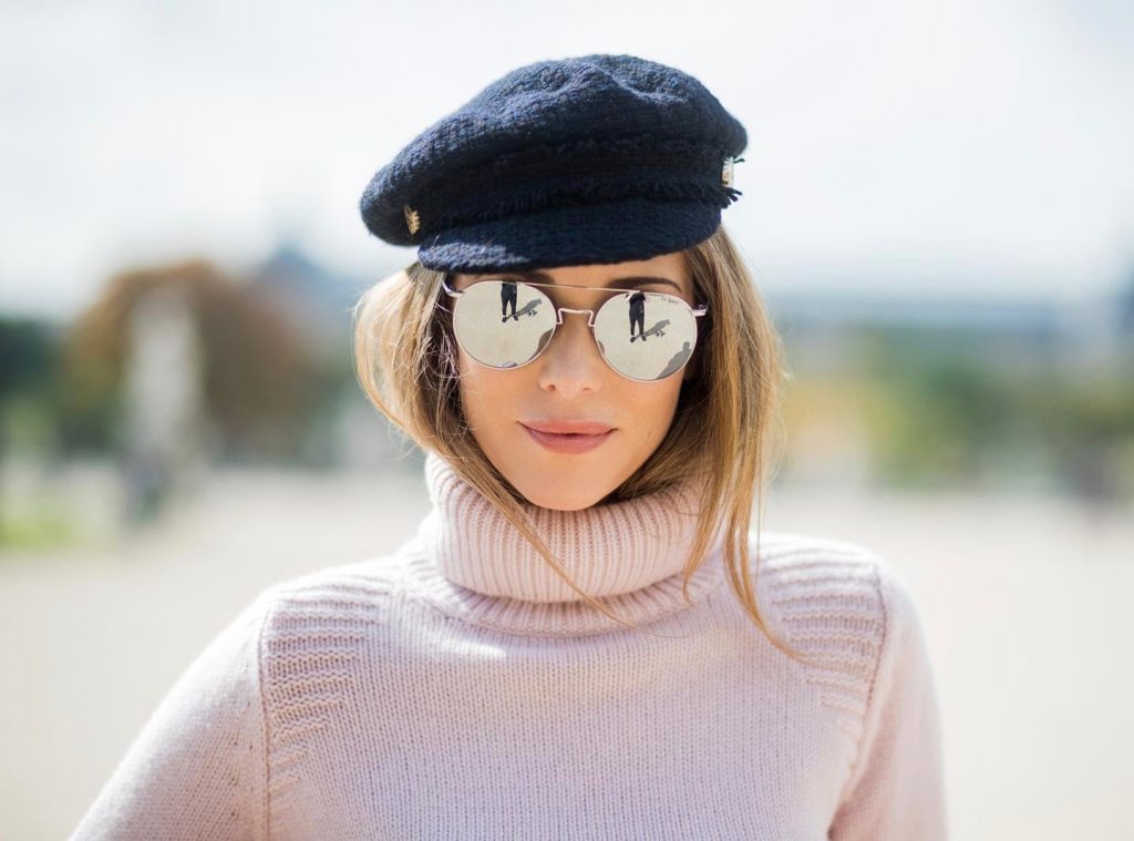 Alexandra Lapp wearing high waist pants in black from Zara, cashmere turtleneck in light pink from Jil Sander, light pink calf leather logo plaque shoulder bag from Karl Lagerfeld, Karl Lagerfeld bag, mirrored sunglasses by Le Specs, hat by Chanel, IWC Portugieser watch and Christian Louboutin Feerica heels with crystal embellished flower and glitter is seen during Paris Fashion Week Spring/Summer 2018 on September 29, 2017 in Paris, France.