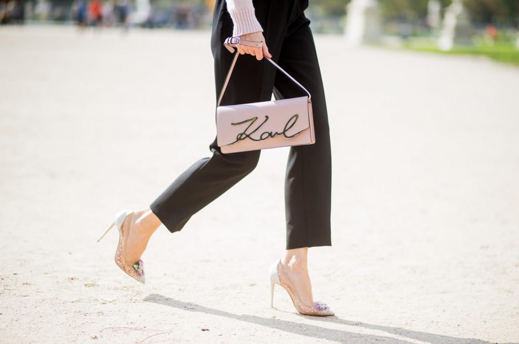 Alexandra Lapp wearing high waist pants in black from Zara, cashmere turtleneck in light pink from Jil Sander, light pink calf leather logo plaque shoulder bag from Karl Lagerfeld, Karl Lagerfeld bag, mirrored sunglasses by Le Specs, hat by Chanel, IWC Portugieser watch and Christian Louboutin Feerica heels with crystal embellished flower and glitter is seen during Paris Fashion Week Spring/Summer 2018 on September 29, 2017 in Paris, France.