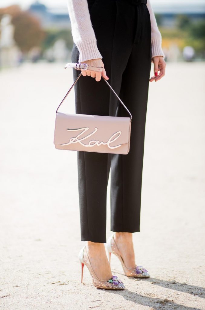 Alexandra Lapp wearing high waist pants in black from Zara, cashmere turtleneck in light pink from Jil Sander, light pink calf leather logo plaque shoulder bag from Karl Lagerfeld, Karl Lagerfeld bag, mirrored sunglasses by Le Specs, hat by Chanel, IWC Portugieser watch and Christian Louboutin Feerica heels with crystal embellished flower and glitter is seen during Paris Fashion Week Spring/Summer 2018 on September 29, 2017 in Paris, France.