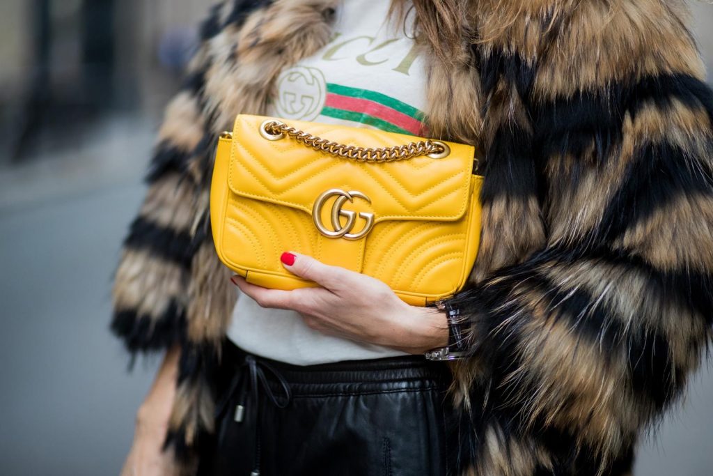 Alexandra Lapp wearing leather trackies in black from Set Fashion, vintage style Gucci logo tee, little fur jacket by Set, yellow GG Marmont matelasse shoulder bag by Gucci, red lacquer heels from Gianvito Rossi and Audrey sunglasses from Celine is seen during Paris Fashion Week Spring/Summer 2018 on September 27, 2017 in Paris, France.
