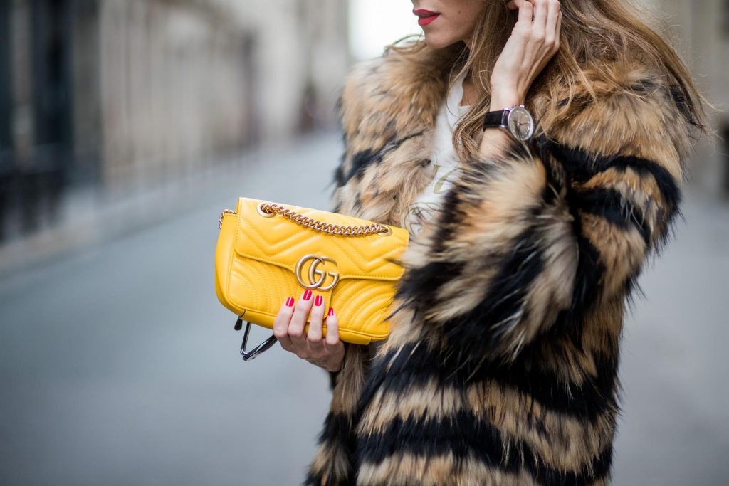 Alexandra Lapp wearing leather trackies in black from Set Fashion, vintage style Gucci logo tee, little fur jacket by Set, yellow GG Marmont matelasse shoulder bag by Gucci, red lacquer heels from Gianvito Rossi and Audrey sunglasses from Celine is seen during Paris Fashion Week Spring/Summer 2018 on September 27, 2017 in Paris, France.