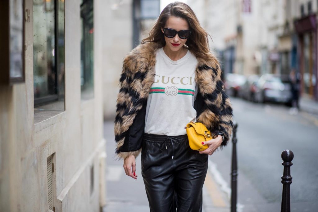 Alexandra Lapp wearing leather trackies in black from Set Fashion, vintage style Gucci logo tee, little fur jacket by Set, yellow GG Marmont matelasse shoulder bag by Gucci, red lacquer heels from Gianvito Rossi and Audrey sunglasses from Celine is seen during Paris Fashion Week Spring/Summer 2018 on September 27, 2017 in Paris, France.