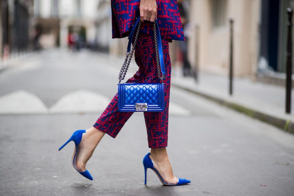 Alexandra Lapp wearing a two-piece suit in red and blue by Riani, a blue lacquer Chanel Boy bag, blue sunglasses by Etnia Barcelona, plexi pumps in blue from Gianvito Rossi and blue tassel earrings from Zara is seen during Paris Fashion Week Spring/Summer 2018 on September 26, 2017 in Paris, France.