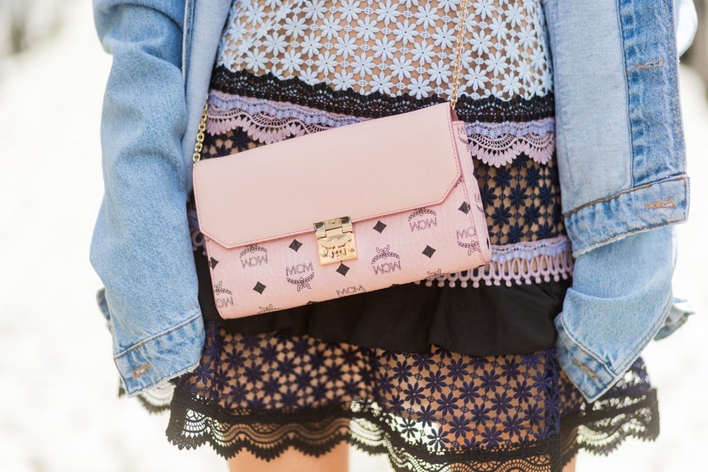 Model and fashion blogger Alexandra Lapp wearing a Self-Portrait dress out of lace in pastel rose, oversized denim jacket from SET, Christian Louboutin Feerica heels with Swarovski crystals and flower accessory, Millie crossbody bag in pink from MCM and sunglasses by Le Specs on August 5, 2017 in Duesseldorf, Germany.
