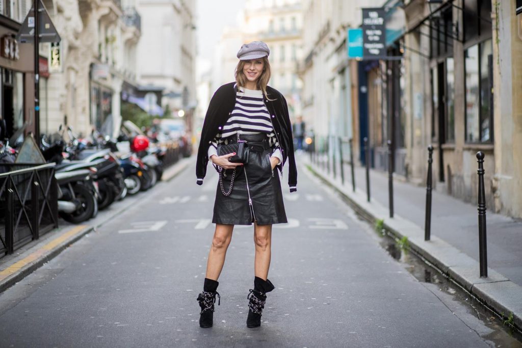 Alexandra Lapp wearing French Chic, an A-line leather rocky biker skirt from SET Fashion, striped knit jumper from Zara, plaid Zara hat, Isabel Marant slouchy boots, detailed with chain-trimmed ties to wrap around the leg, black Boy bag from Chanel and velvet bomber jacked with a Cosmo application is seen during Paris Fashion Week Spring/Summer 2018 on September 29, 2017 in Paris, France.