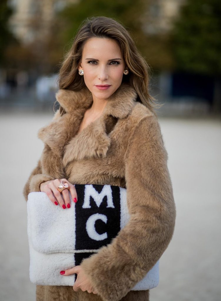 Alexandra Lapp wearing Morganite jewelry, rings and earrings by Schubart an oversized MCM Stark Pouch in Shearling Stripe, a lambskin coat in light brown by Yves Salomon, black and white big waist-belt from Balmain and striped Christian Louboutin 'So Kate' heels is seen during Paris Fashion Week Spring/Summer 2018 on September 28, 2017 in Paris, France.