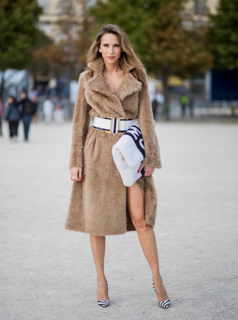 Alexandra Lapp wearing Morganite jewelry, rings and earrings by Schubart an oversized MCM Stark Pouch in Shearling Stripe, a lambskin coat in light brown by Yves Salomon, black and white big waist-belt from Balmain and striped Christian Louboutin 'So Kate' heels is seen during Paris Fashion Week Spring/Summer 2018 on September 28, 2017 in Paris, France.