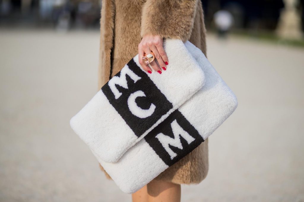 Alexandra Lapp wearing Morganite jewelry, rings and earrings by Schubart an oversized MCM Stark Pouch in Shearling Stripe, a lambskin coat in light brown by Yves Salomon, black and white big waist-belt from Balmain and striped Christian Louboutin 'So Kate' heels is seen during Paris Fashion Week Spring/Summer 2018 on September 28, 2017 in Paris, France.